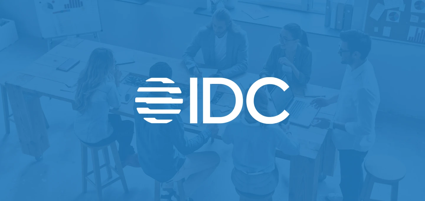 IDC logo over a blue background showing a group of people working together at a table.